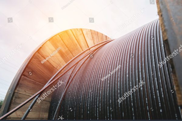 stock-photo-black-wire-electric-cable-with-wooden-coil-of-electric-cable-under-the-sky-718847128